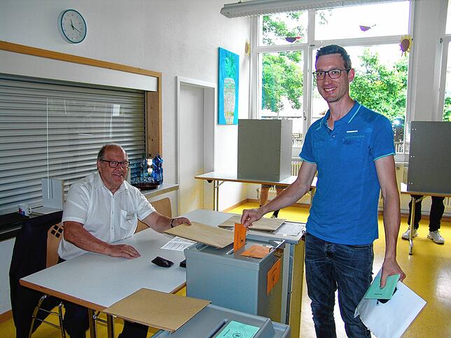 Micha Knecht (rechts) wirft gerade seinen Stimmzettel in die Urne. Gemeinderat Peter Frick unterstützt am Wahlsonntag als Wahlhelfer in ...