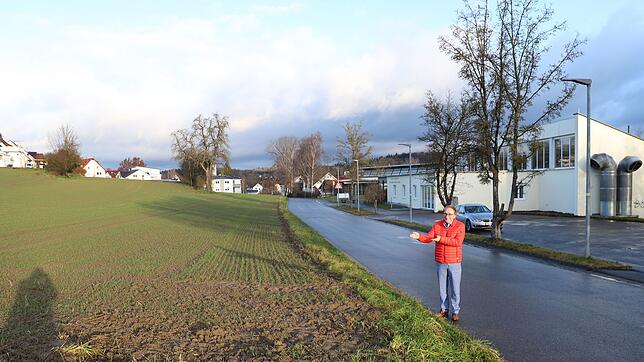 Hier kommt der Neubau hin: Bürgermeister Edgar Lamm zeigt auf das Feld am Kanalweg beim Hallenbad in Mühlhofen, wo 2020 das neue ...