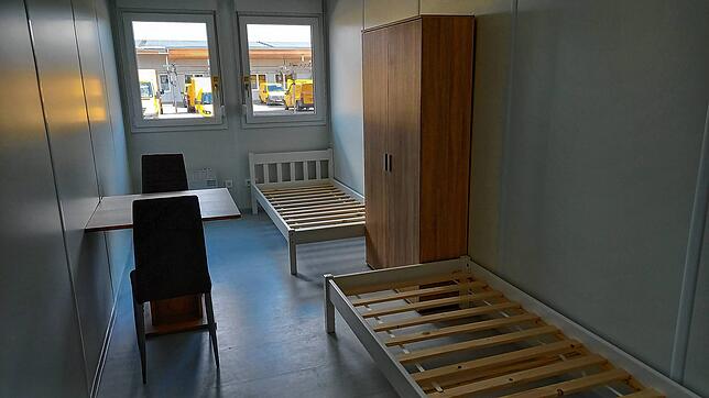 Zwei Betten, ein Schrank, ein Tisch – das ist ein Schlaf- und Wohnraum.
