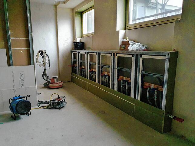 Im Duschraum werden auch Waschbecken aufgebaut. Die erste Installation an der Wand ist schon befestigt.