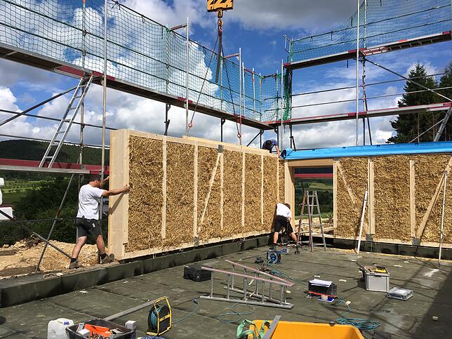 Ein Blick auf das Haus in der Bauphase. Gut zu erkennen: Die Strohballen, die zwischen die Holzelemente gepresst wurden.