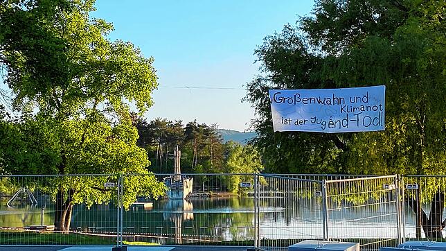 Banner, Schlosssee und Bauzaun auf einem Bild. Mit dem Schriftzug wollen die Klimaaktivisten gegen den Regionalplan protestieren, der in ...
