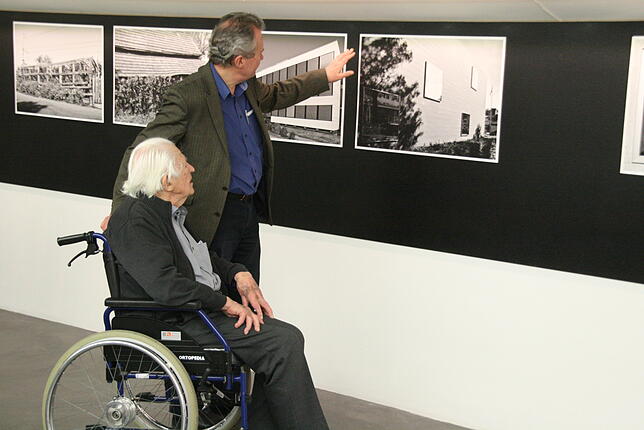 Erwin und Christoph Rehmann betrachten Fotografien von Philipp Fuchs.