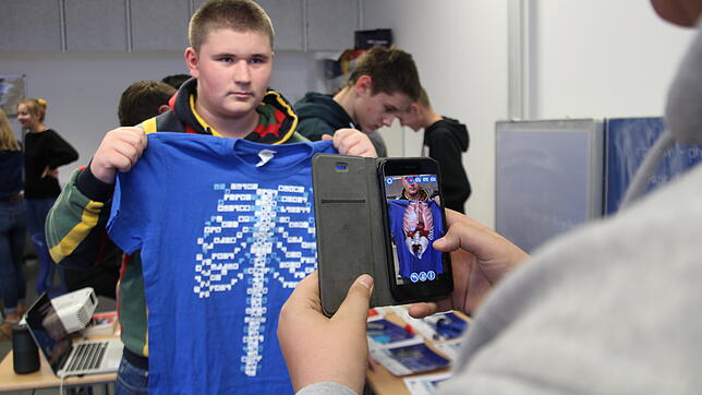 Technik zum Anfassen: Niko Mikic hält ein T-Shirt vor den Körper, auf dem per Handy-Klick die Organe des Menschen sichtbar werden. ...