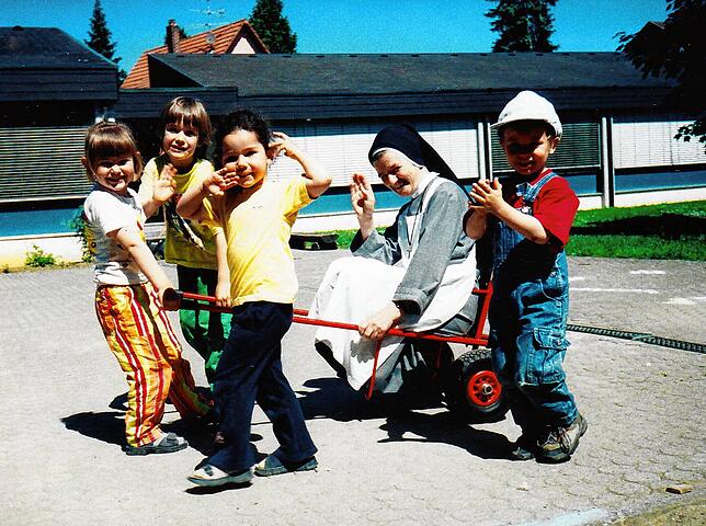 Schwester Itta war mit ihren Zöglingen immer für einen Spaß zu haben. Hier wird die zierliche Kindererzieherin auf einer Sackkarre ...