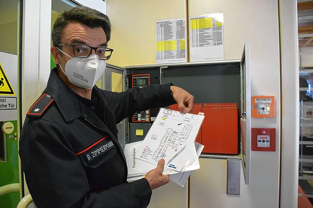 Bernd Zimmermann zeigt und erklärt die Laufkarten im Feuerwehrinformationszentrum (FIZ) des Krankenhauses.