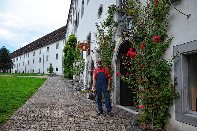 Michael Denker steht vor der Schmiede. Der SÜDKURIER soll mal wiederkommen, wenn die Rosen besonders schön blühen.