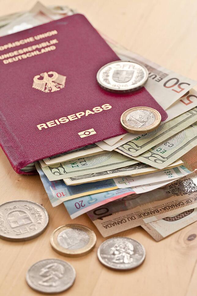 Deutscher Reisepass mit verschiedenen Währungen.