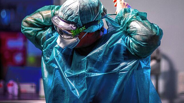 Volle Schutzkleidung: So arbeiten Pfleger auf den Intensivstationen der Krankenhäuser im Umgang mit Covid-Patienten bis heute. Bild: dpa