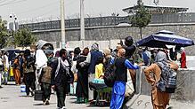 Menschen begeben sich zu einer Militäreinrichtung auf einem Flughafen in Kabul, nachdem die militante islamische Gruppe der Taliban ...