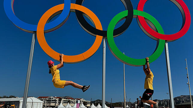 Anna Markfort und Simon Diesch machen Klimmzüge an den olympischen Ringen.