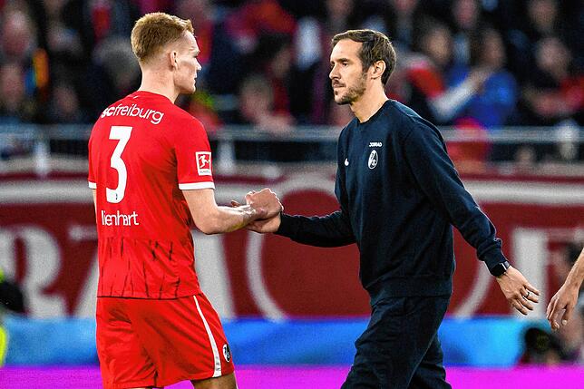 Freiburgs Trainer Julian Schuster (r) klatscht nach dem Spiel mit Freiburgs Philipp Lienhart (l) ab.