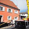 Ein Autokran hebt den Narrenbaum über das Dach zum Dachfenster des Treppenhauses.