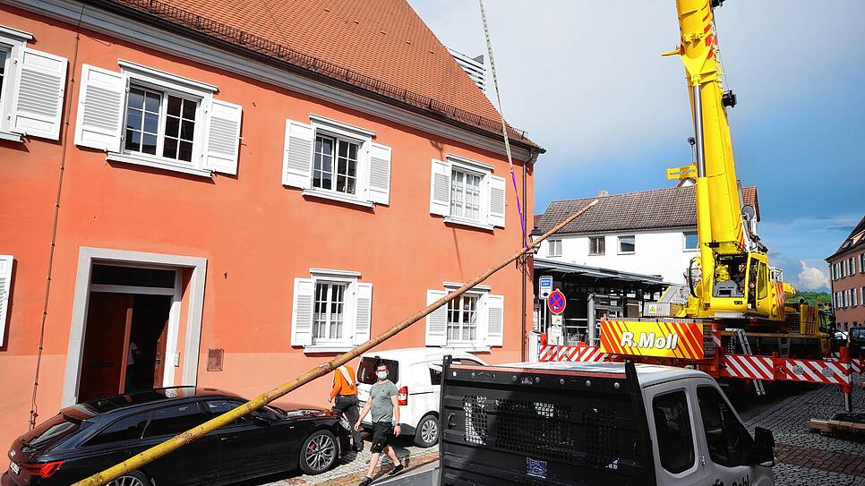 Ein Autokran hebt den Narrenbaum über das Dach zum Dachfenster des Treppenhauses.