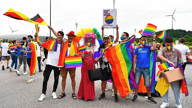 Deutsche Fans halten vor der Allianz-Arena Regenbogenflaggen in die Höhe. Sie demonstrieren gegen das Verbot der UEFA, das Stadion in ...