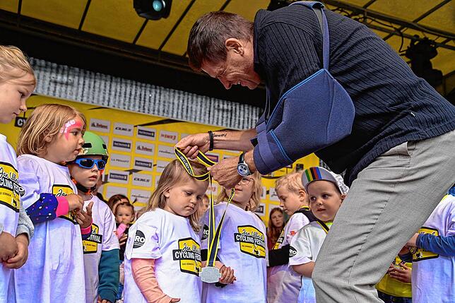 Trotz Handicap lässt es sich Jan Ullrich nicht nehmen, den Teilnehmern des Laufradrennens persönlich eine Medaille um den Hals zu hängen.