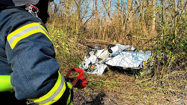 Feuerwehrleute erreichen das Wrack der abgestürzten zweisitzigen Maschine vom Typ &bdquo;Grumman&ldquo; am Sonntagnachmittag, 27. März. ...