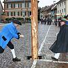 Narrenvater &bdquo;Hubert I.&ldquo; Rössler und Narrenbolizei Michael Bauer sägen am Stamm des Narrenbaums. Im Hintergrund links spannen ...