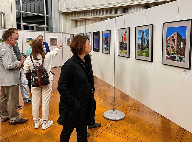 Besucher diskutieren im Bürgersaal über die verschiedenen Herangehensweisen der Fotofreunde Singen in der Ausstellung „Singen und Hegau ...