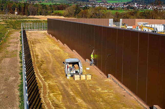 Die Gefängnismauer um das Gelände ist fast fertig. Bei einer Zollkontrolle erfüllt sie erstmals ihren Zweck: Flüchtende aufhalten.
