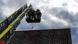 Die Feuerwehrleute setzen die Drehleiter ein. Im Korb sind sie aber nicht allein.