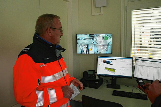 Martin Tanner vor den Bildschirmen, auf denen die Abmessungen der Lastwagen sekundenschnell erscheinen.