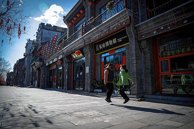 Ein Bild aus Peking, aufgenommen am 16. Februar 2020: Arbeiterinnen mit Mundschutz springen Seil auf der Menschenleeren Qianmen Straße, ...