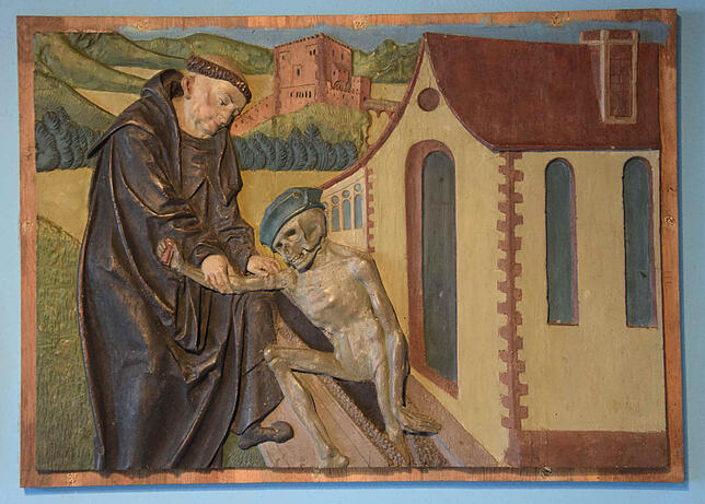 Ein spätgotisches Relief aus der Zeit um 1500 im Stiftsschatz des St. Fridolinsmünsters in Bad Säckingen zeigt Fridolin mit den Gebeinen ...