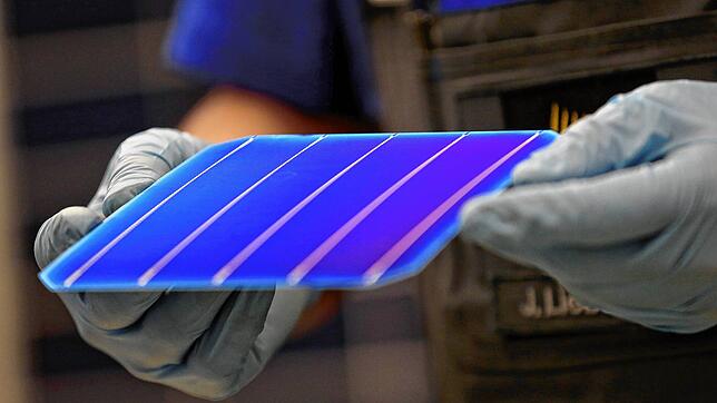 Ein Mann hält eine Solarzelle zur Sichtprüfung. Die Solar-Maschinen zur Fertigung kommen oft aus dem Südwesten. Aber die Hersteller sind ...