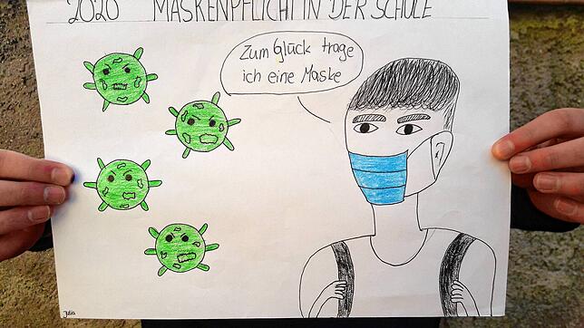 Julia Vugrinec fühlt sich mit Maske sicherer &ndash; und der Figur auf ihrer Karikatur geht es genau so.