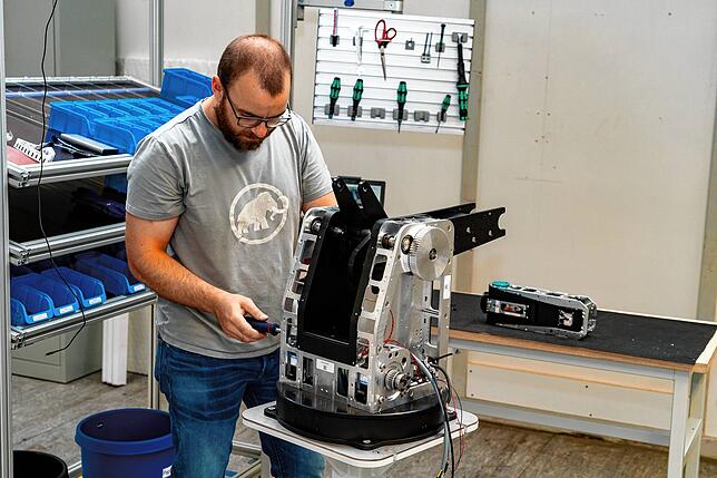 Mitarbeiter Paul Schultz bei der Montage eines Roboters.