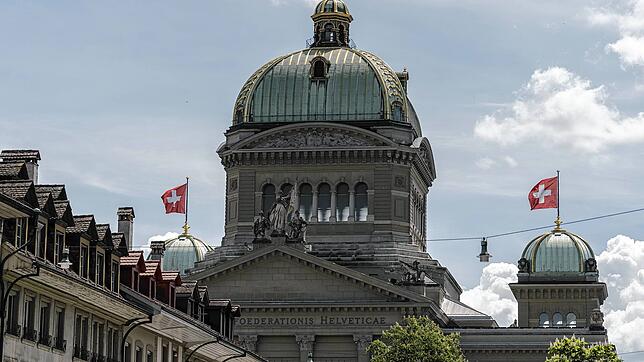 Die Schweizer Nationalfahne weht auf den Kuppeln des Bundeshauses in Bern. Hier wird im Herbst die Entscheidung fallen, ob die Polizei ...
