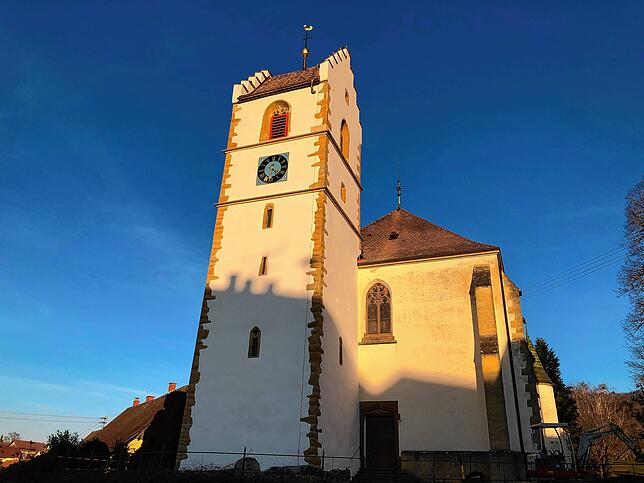 Der Binninger Kirchturm leuchtet in der Abendsonne.