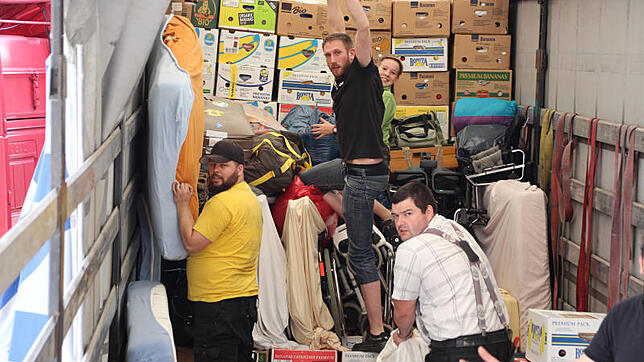 Jeder Handgriff sitzt, und die Jungs haben längst Routine im Packen. Wo Lücken entstehen, werden diese mit Kleidersäcken und Matratzen ...
