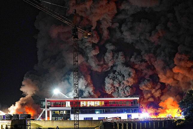 Rauch steigt von einem Brand auf dem Gelände eines Reifengroßhändlers auf während die Feuerwehr löscht.