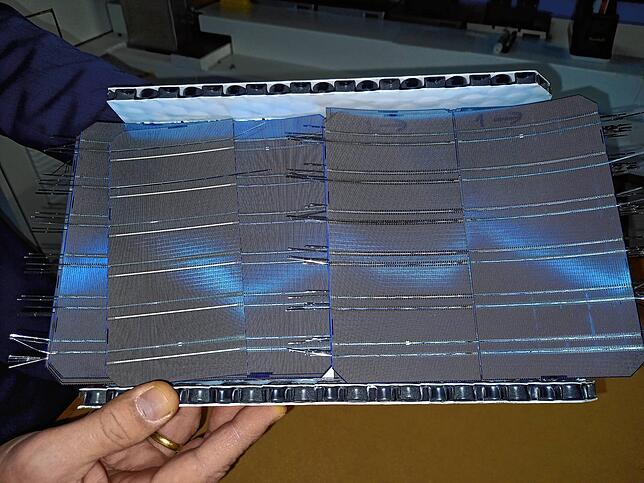 Kristian Peter zeigt hier aneinander gelötete Solarzellen.