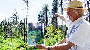 Der Biologe Heinz-Michael Peter zeigt auf einem Foto, wie das Horbacher Moor einst aussah. Foto: Steffen Schmidt