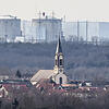 Der Kirchturm der katholischen Kirche St. Peter und Paul in Deutschland steht vor dem Atomkraftwerk Fessenheim in Frankreich.