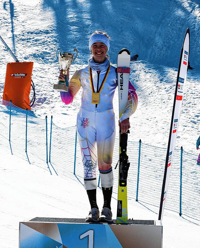 Lena Kiefer mit ihren Ski, dem Pokal für den ersten Platz und einer Goldmedaille.