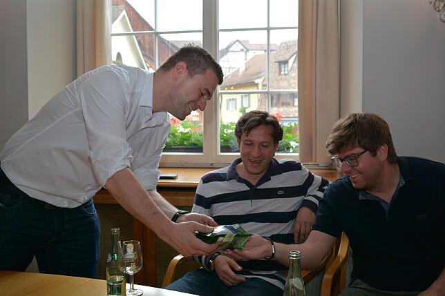 Der neue Hauptamtsleiter Steffen Lebherz verteilt nach der Auszählung &bdquo;Wahl-Nüsse&ldquo; an Michael Dörr und Marc Pfeiffer von der ...