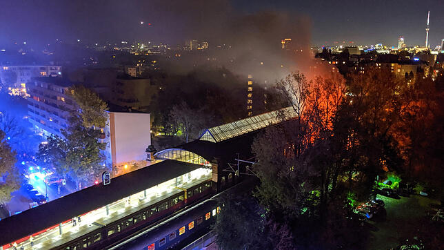 Ein Sonderzug eines privaten Bahnunternehmens (vorn) steht brennend im S-Bahnhof Bellevue.
