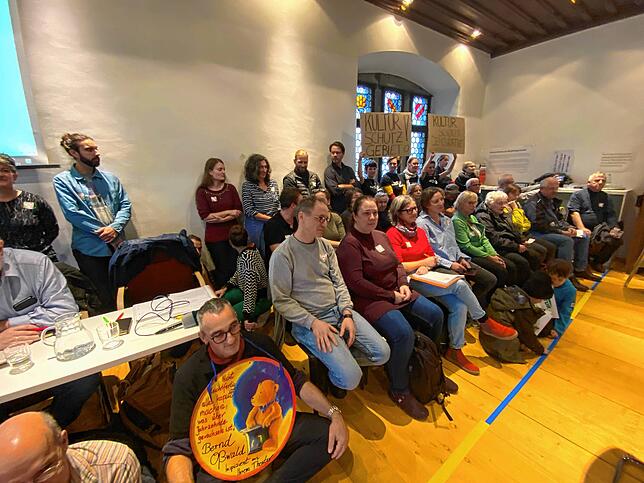 Sie fordern auf Transparenten den Erhalt des „Kulturschutzgebiets“: Zuschauer bei der Gemeinderatdebatte im Ratssaal.
