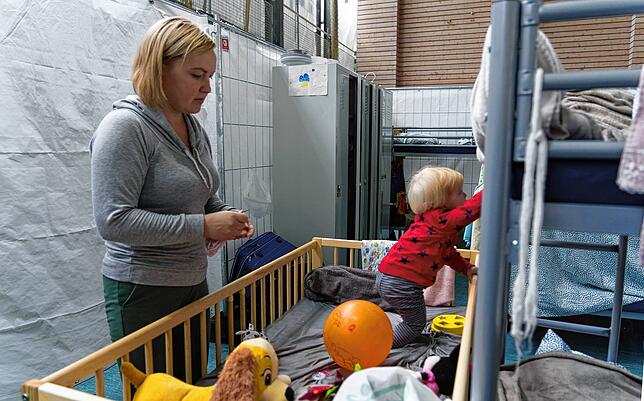 Die kleinen Abteile in der Notunterkunft sind spärlich eingerichtet und müssen von mehreren Familien geteilt werden. Stockbetten und ...