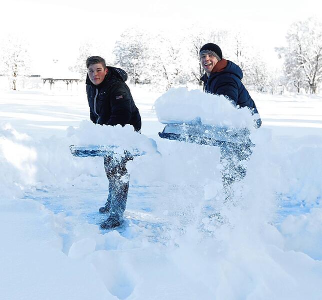 Marvin (links) und Lukas haben am Freitag trotz der Schneemassen Spaß beim Schaufeln. Die Sonne lacht ihnen jedenfalls zu.