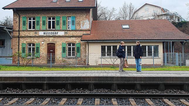 Zwei junge Menschen stehen am Haltepunkt der Bahn in Überlingen-Nußdorf. Das alte Bahnhofsgebäude mit Anbau dient als Jugendtreff und ...