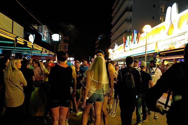 In der Bierstraße am Ballermann gehen Menschen an den Bars Bierkönig und Bamboleo vorbei.