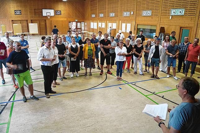 Martin Grünmüller vom ASU weist die Besucher des Informationsabends zum Neubaugebiet II in der Thingotlhalle ein.