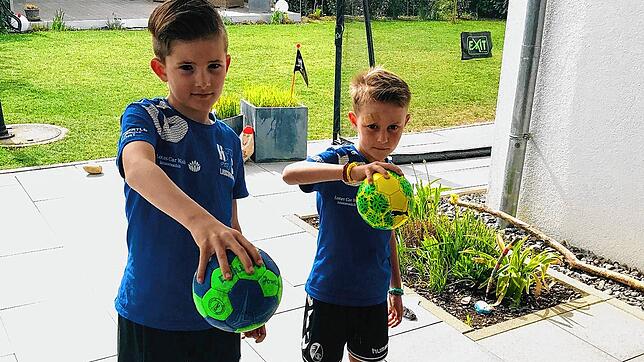 Heimtraining bei der Handball-Familie Busch: Jonathan (8) und sein Bruder Samuel (6) mit Handbällen in der Hand, zeigen Übungen, die auf ...