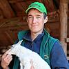 Albert Hahn (35) mit einem Lamm vor seinem Stall in Peterzell.