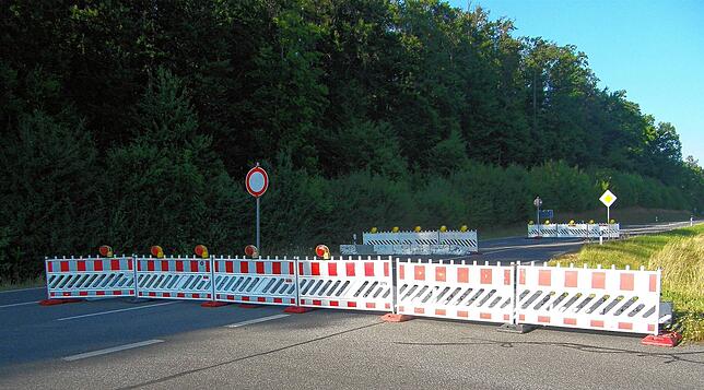 Die Absperrung der L220 bei der nördlichen Ausfahrt der Waldsiedlung ist so aufgestellt, dass sie in langsamem Tempo umfahren werden kann.
